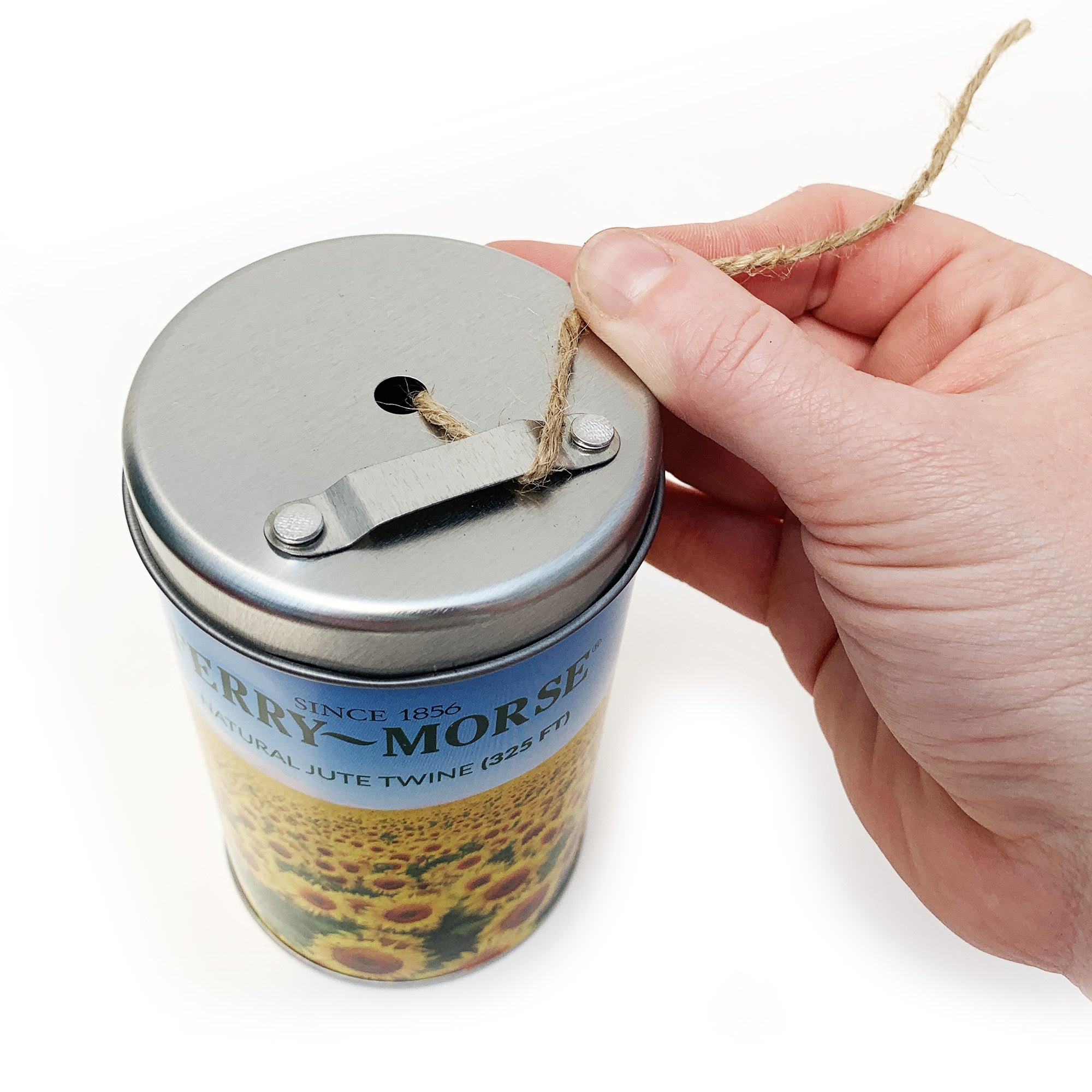 A spool of Ferry-Morse natural jute twine in a tin canister with a sunflower field design.
